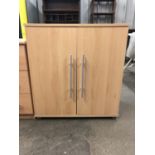 A contemporary light beech effect two door cupboard, 67 x 35 x 72 cm