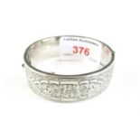 A 1950s silver hinged bangle with foliate engraving to the face, Chester, 1956, 27.1g