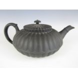 A 19th Century Wedgwood black basalt teapot of compressed and lobed form (a/f) (chip to underside of