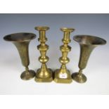 A pair of brass candlesticks together with one other pair of spill vases