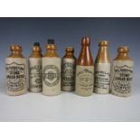 Seven stoneware bottles including examples of J Cartmou and Co Whitehaven and Armstrong and Dickie