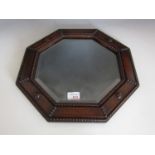 An octagonal oak framed bevelled mirror
