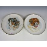 A pair of hand-enamelled earthenware wall plaques depicting dogs, signed Cooper