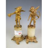 A pair of gilt metal cupids on alabaster socles