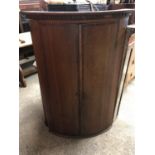 A 19th century oak bow fronted hanging corner cupboard with mahogany cross banding, 75 x 48 x 119