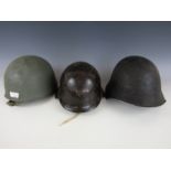 A Swiss Model 1918, a Bulgarian and one other steel helmet