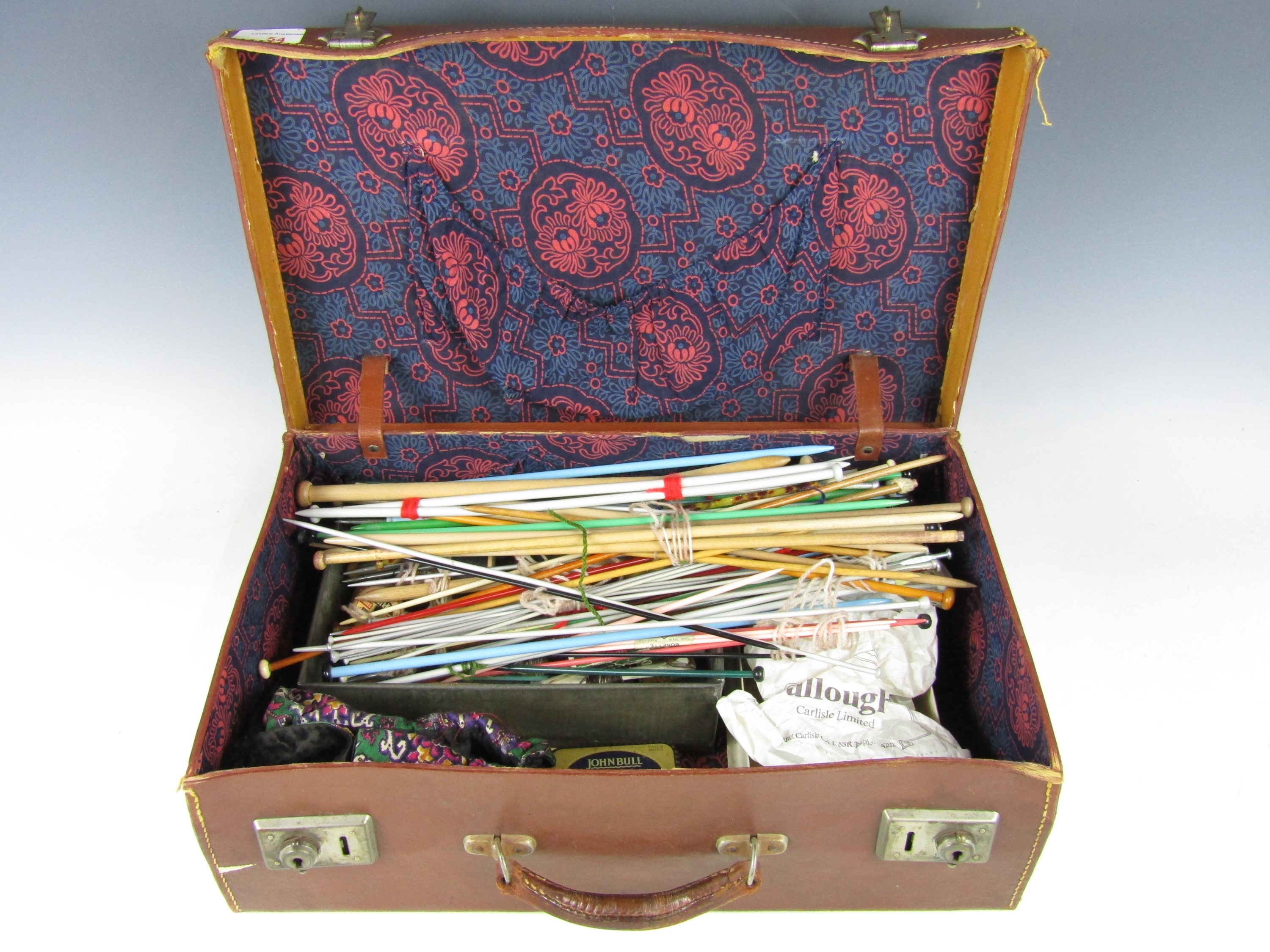 A vintage hide case containing sundry sewing and knitting accessories