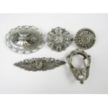 Four early 20th Century white metal brooches, together with a white metal pendant photograph