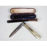 A Victorian silver and mother of pearl folding fruit knife together with two cheroot holders