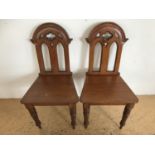 A pair of Victorian Gothic revival oak hall chairs