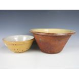 A large earthenware bowl together with a colander