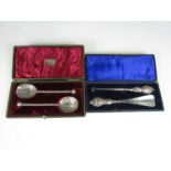 A cased pair of electroplate fruit spoons together with a cased silver handled button hook and