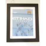 A Manchester City signed football shirt, framed and mounted under glass