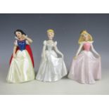 A set of three Disney figurines including Snow White, Cinderella and Sleeping Beauty