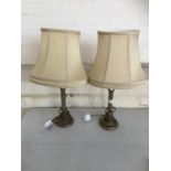 A pair of brass table lamps with oval shades