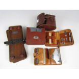 A quantity of 1930s-1940's gentlemen's leather-cased grooming sets and a tie press