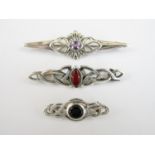 Three contemporary white metal bar brooches, two in the form of Celtic knots and each set with a