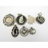 Seven silver and white metal pendants, including a Wedgwood plaque, a horoscope pendant, and a