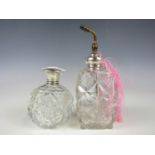 An early 20th Century silver-mounted cut glass perfume atomizer and a silver-capped toiletry bottle