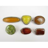 Six vintage white metal and polished hardstone brooches, including one in moss agate