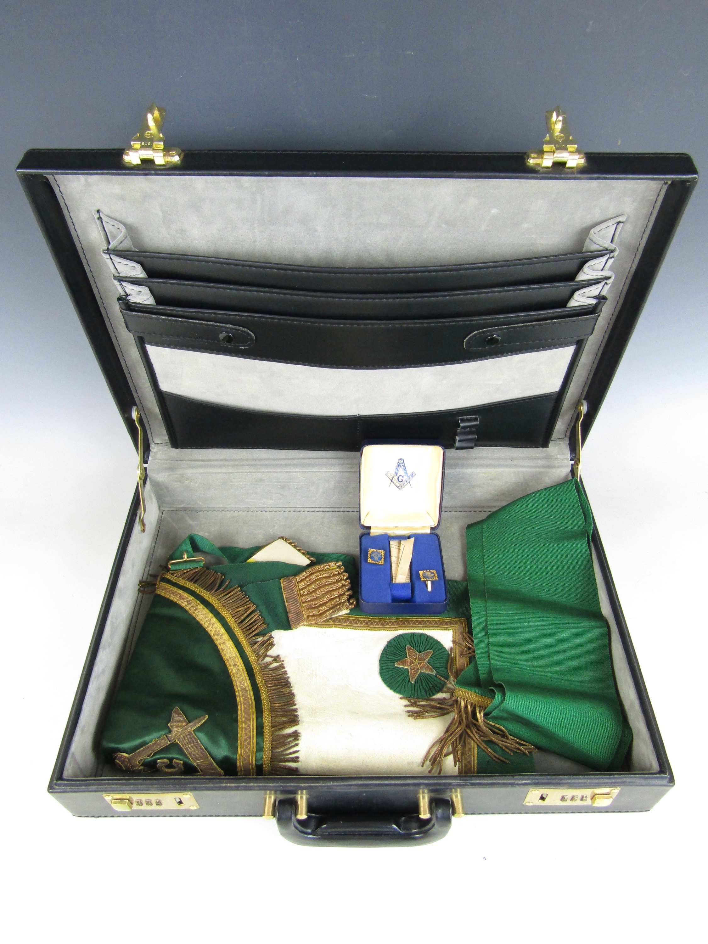 A vintage briefcase containing Masonic regalia including a cased set of Masonic cuff links