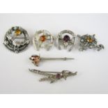 Six Scottish brooches in white metal, including one modelled in the form of a basket-hilted