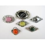 Vintage Arts and Crafts style white metal brooches, each centrally set with a polished or faceted