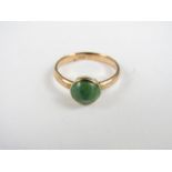 A vintage yellow metal and green stone cabochon ring, stamped 9ct