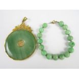 A jade bead bracelet with yellow metal clasp, together with a similar pendant with gold plated