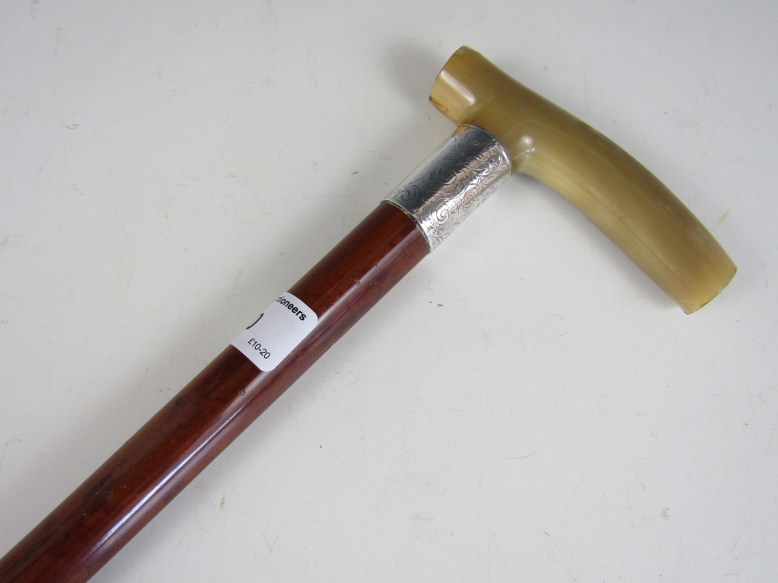 A horn handled and silver collared walking cane