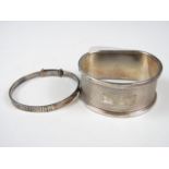 A silver napkin ring together with a baby's bangle