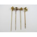 Four late 19th / early 20th Century rolled gold stick pins, one with Art Nouveau terminal set with