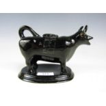 A Victorian black-glazed cow creamer