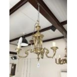 A large elaborate brass eight-branch chandelier