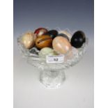 A glass comport together with a quantity of stoneware and onyx eggs