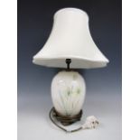 A contemporary ceramic lamp base decorated with daffodils