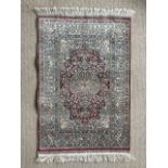 An oriental hand woven rug in dense red and blue design, 93 x 63 cm (4)