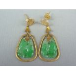 A pair of jade and yellow metal pendant earrings, with Chinese character ear stud, above a dependent