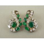 A pair of emerald, diamond and white metal cocktail earrings, in a scrolling arrangement