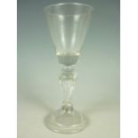 A mid-18th Century wine glass with Silesian stem, having conical funnel bowl, typical tapering