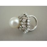 A diamond and pearl cocktail ring, in high carat white metal, with central pearl held above a tiered