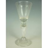 A mid-18th Century wine glass with Silesian stem, having conical funnel bowl, typical tapering