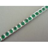 An emerald and high-carat white metal bracelet, with square cells each sunken and claw set with a