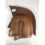 A vintage carved wall plaque in the form of the profile of a Greek warrior