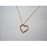 A yellow metal heart shaped pendant on chain, the latter stamped 750, 3.1g total