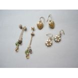 Three pairs of yellow metal pendant earrings, one pair having a diamond cluster stud earring above