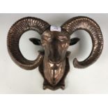 A cast and bronzed rams head wall sculpture