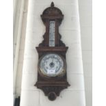 A vintage carved oak cased barometer