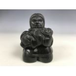 An Inuit carved stone sculpture of mother and child, signed Thorn