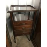 A mahogany music cabinet with brass castors